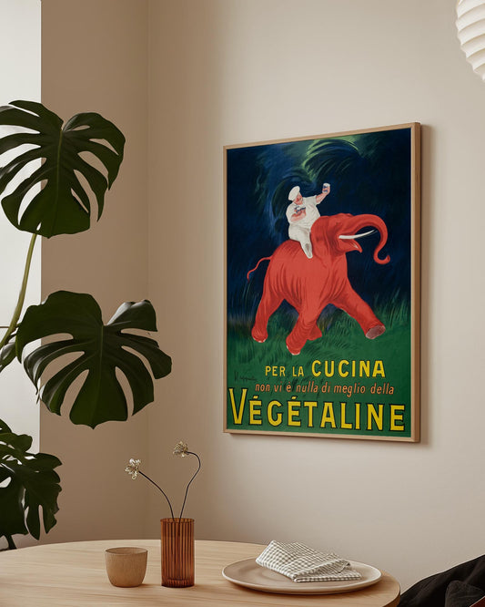 Vintage Végétaline advertisement by Leonetto Cappiello featuring a cheerful chef in white riding a bold red elephant through a dark jungle, holding cans of Végétaline. Bold typography and vibrant colors create a striking, whimsical composition.